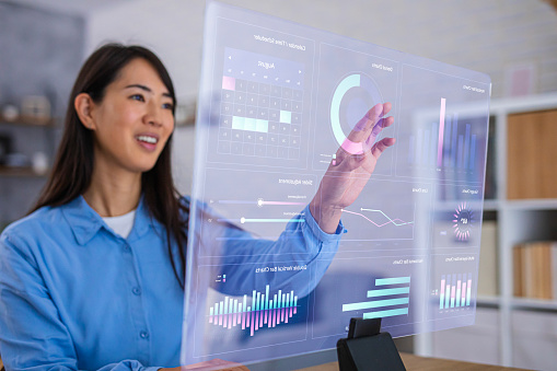 A team member interacting with a translucent dashboard of charts and metrics
